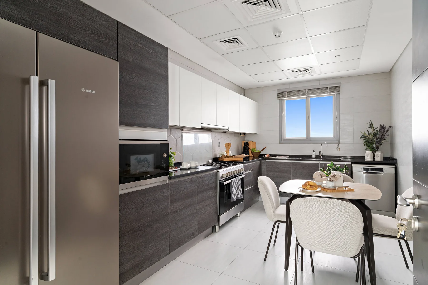 Una cocina moderna con gabinetes oscuros, electrodomésticos y una mesa de comedor.