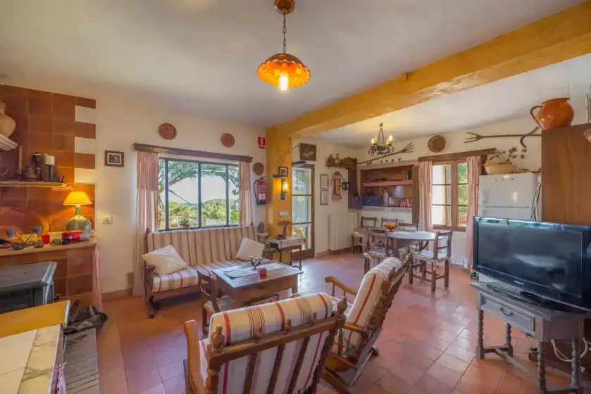 Una sala de estar con asientos, una mesa de centro y un televisor.