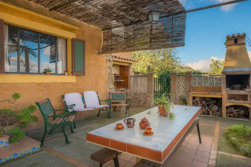 A tiled patio dining area sits beside a built-in outdoor barbecue.