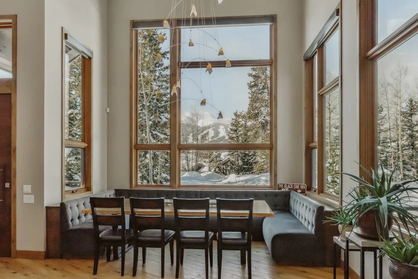 A dining nook with a table and seating beside large windows.
