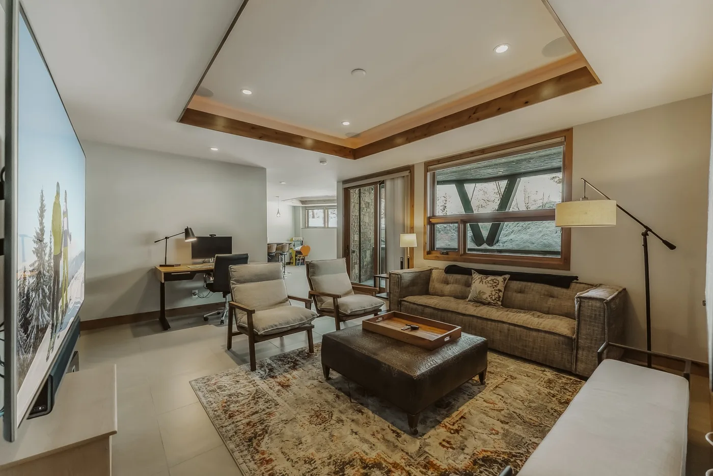 A living room with seating arranged around a low coffee table and rug.
