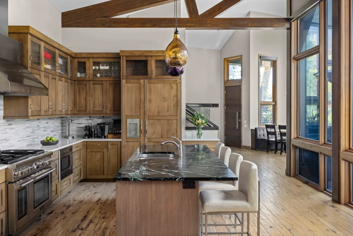 A spacious kitchen with a central island and large windows.