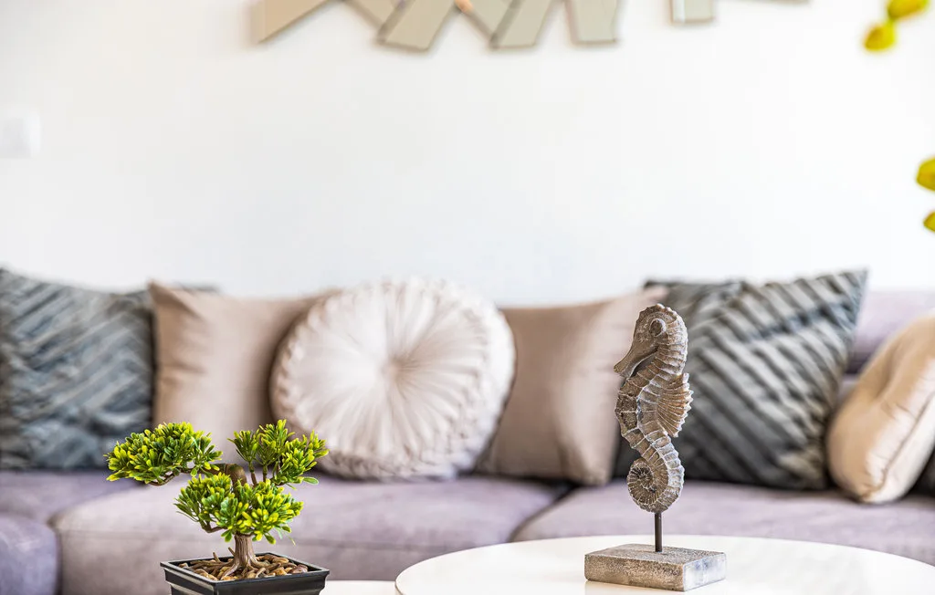 A living room seating area with patterned cushions and decorative displays.