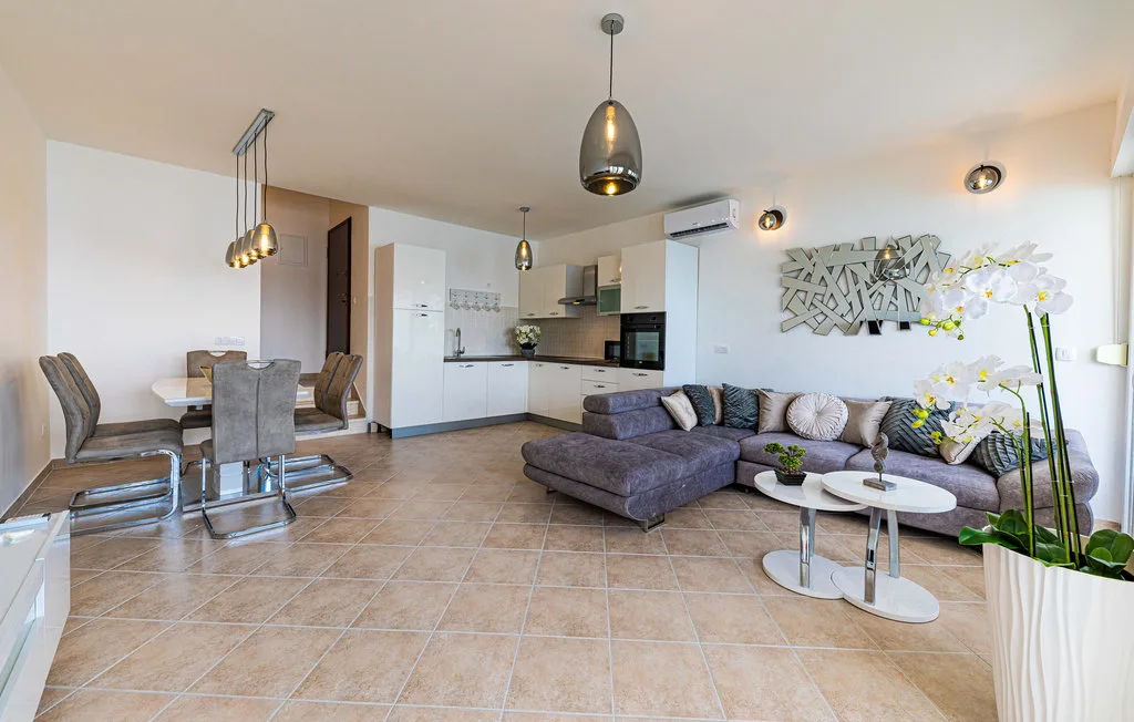 Una sala-comedor diáfana con sofá seccional y cocina.