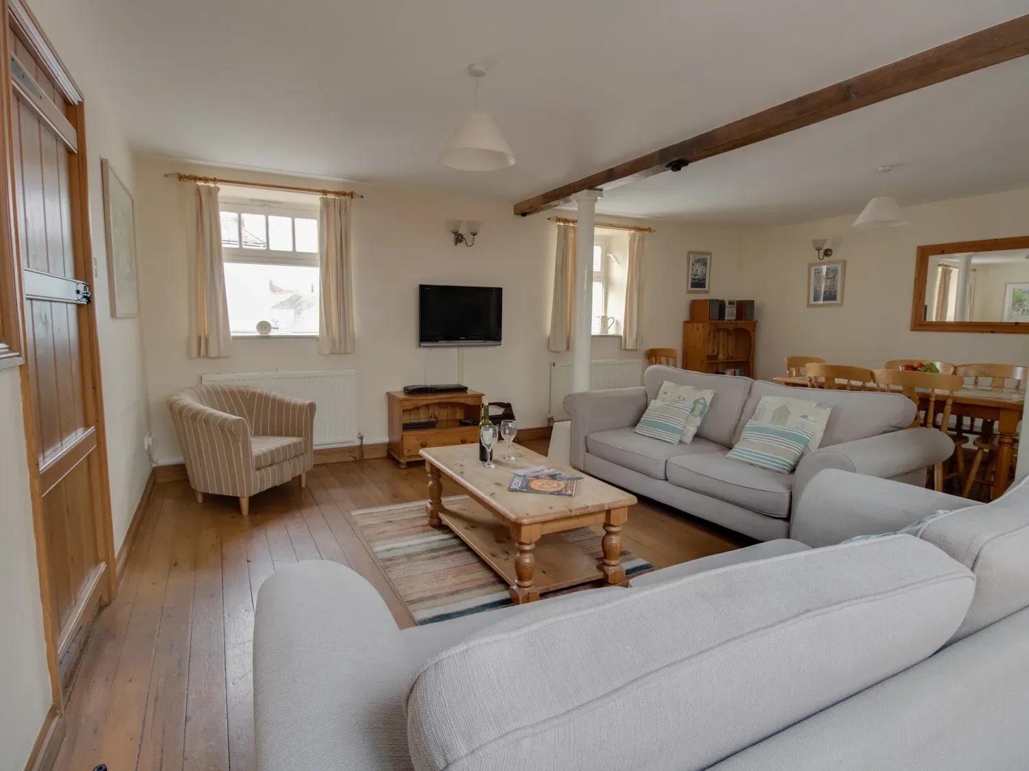 A living room with sofas a wooden coffee table a television and a dining table at Georges House in Brewers Quay Harbour