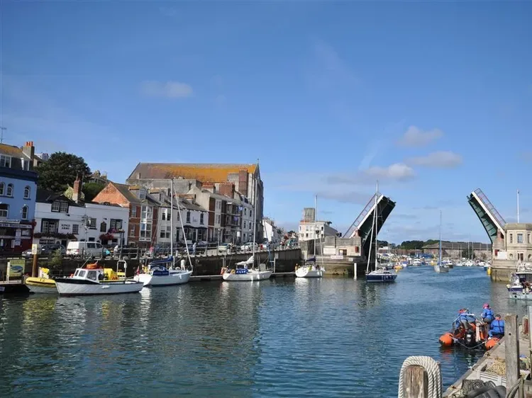 A harbor channel runs between waterfront buildings and raised drawbridges.