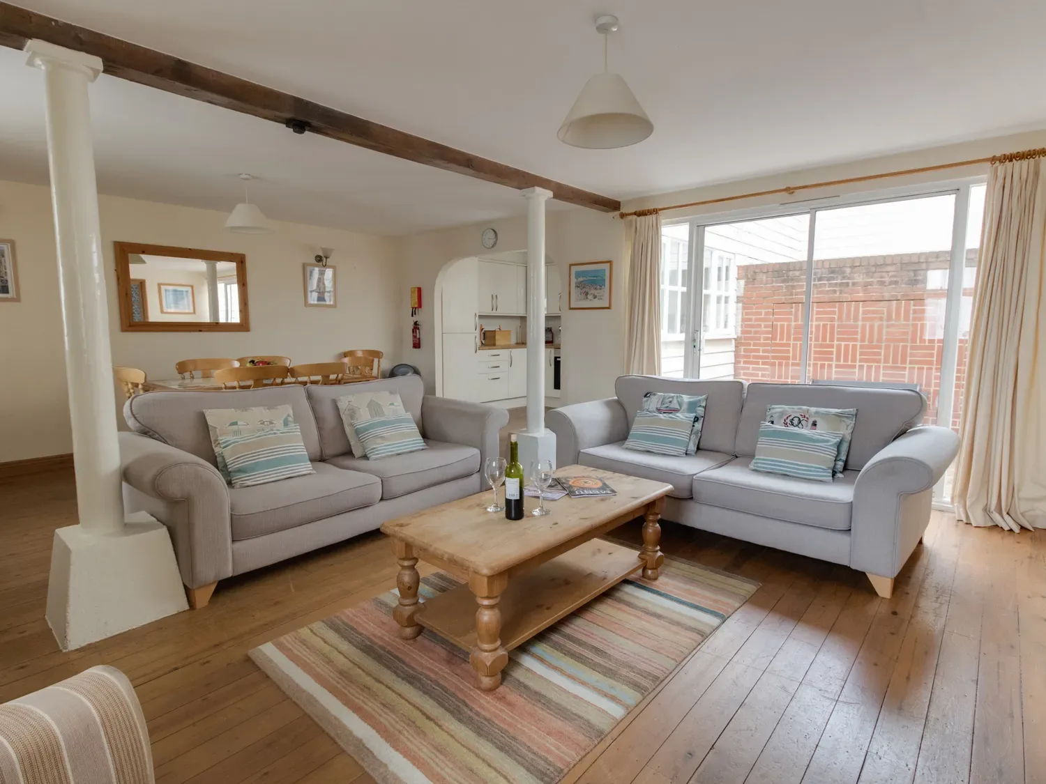 A living room with seating around a wooden coffee table on a striped rug.