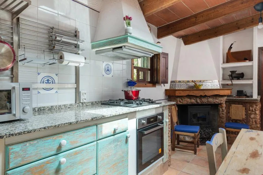Una cocina con encimera de azulejos y cocina junto a un comedor.