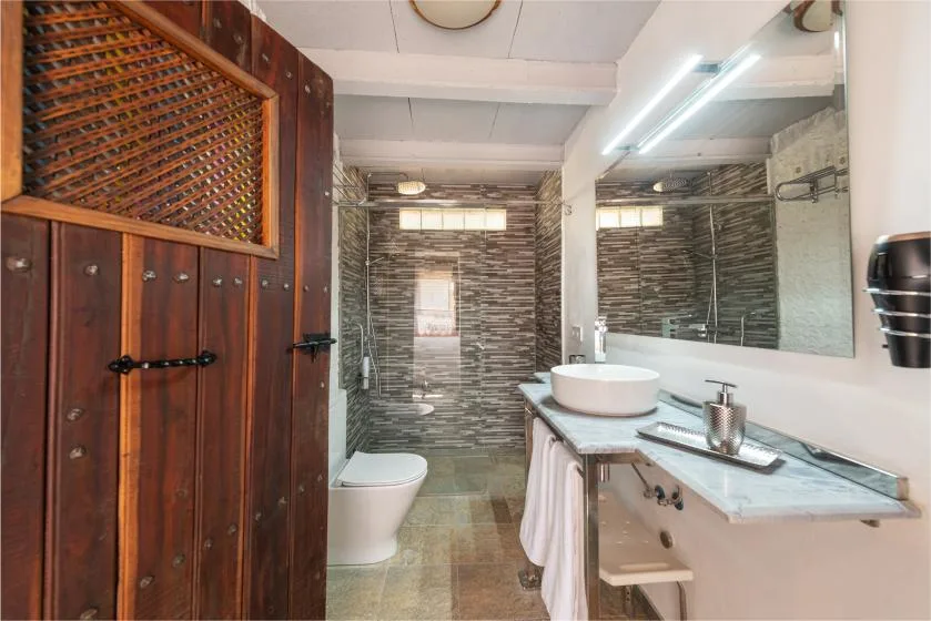 Un baño con ducha de vidrio, inodoro y lavabo.
