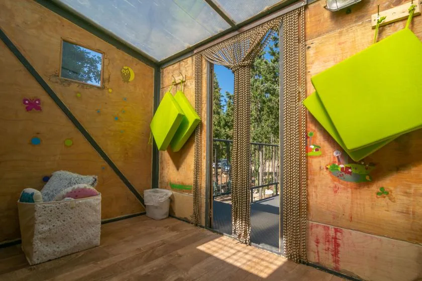 Una sala de juegos colorida con paneles verdes brillantes y una puerta de vidrio.