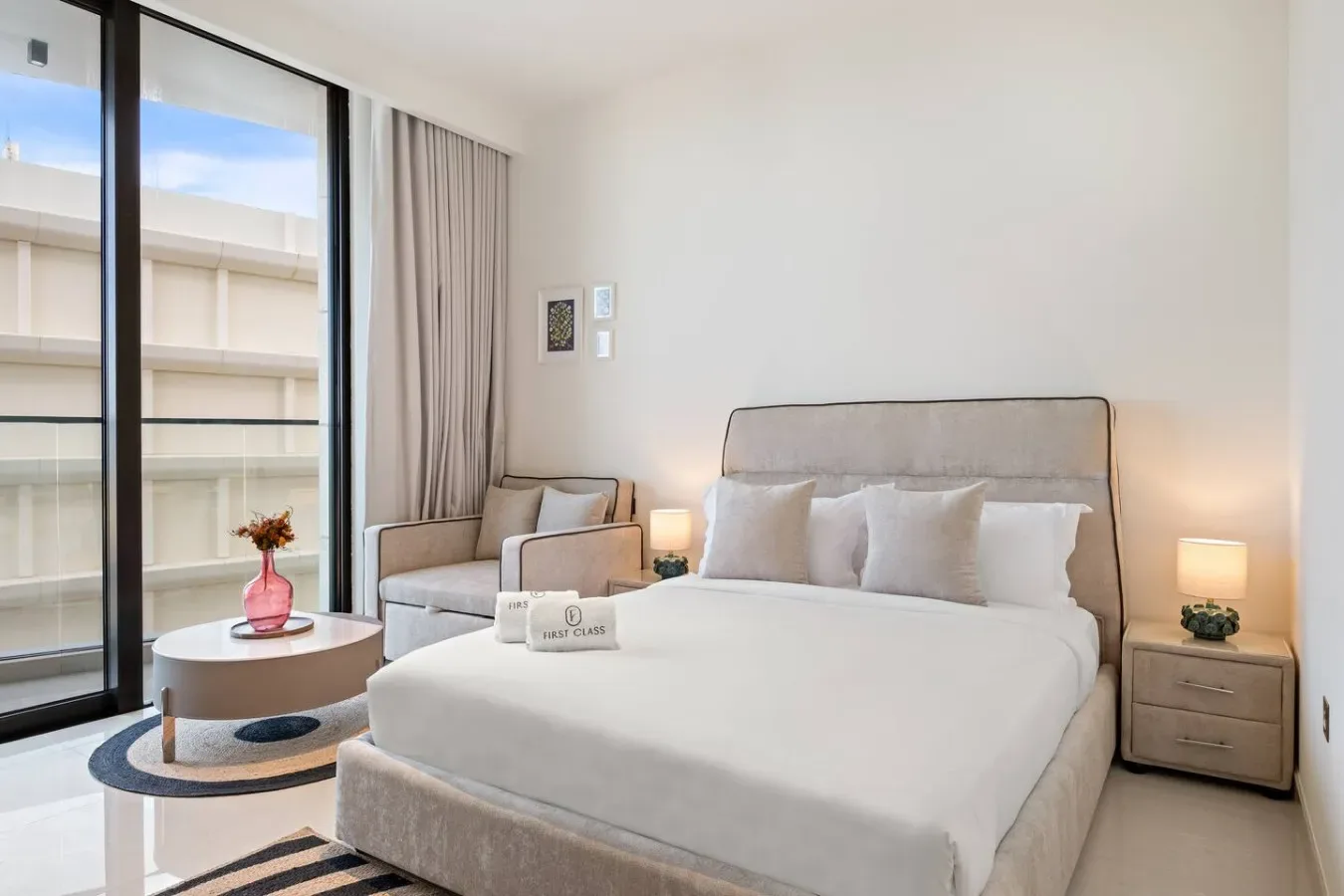 Un dormitorio luminoso con una cama grande, mesitas de noche y ventanales.