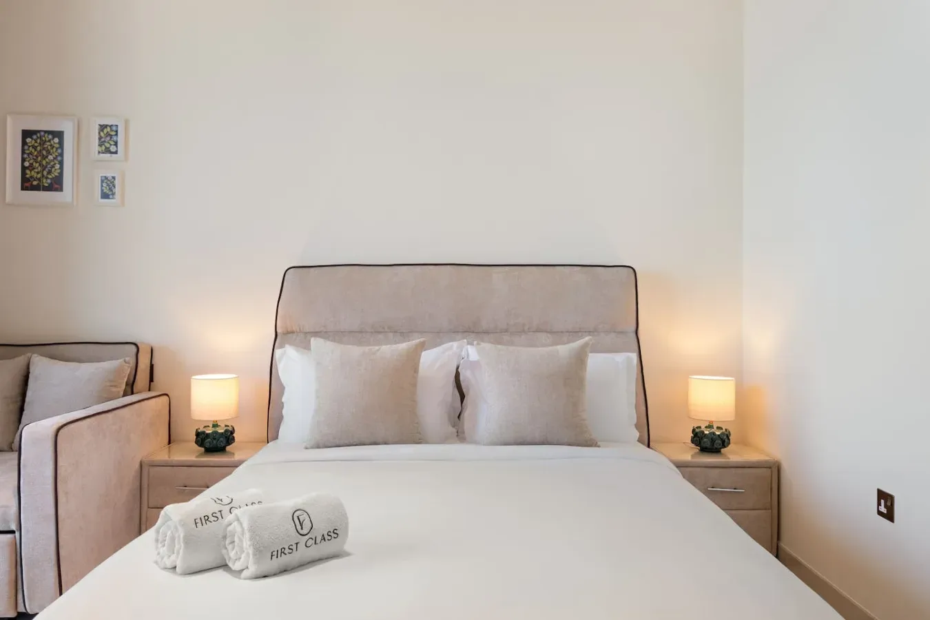 Un dormitorio con una cama bien arreglada y toallas dobladas.