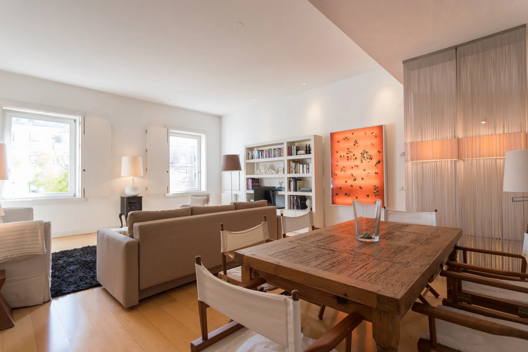 A living and dining area with a wooden table and seating.