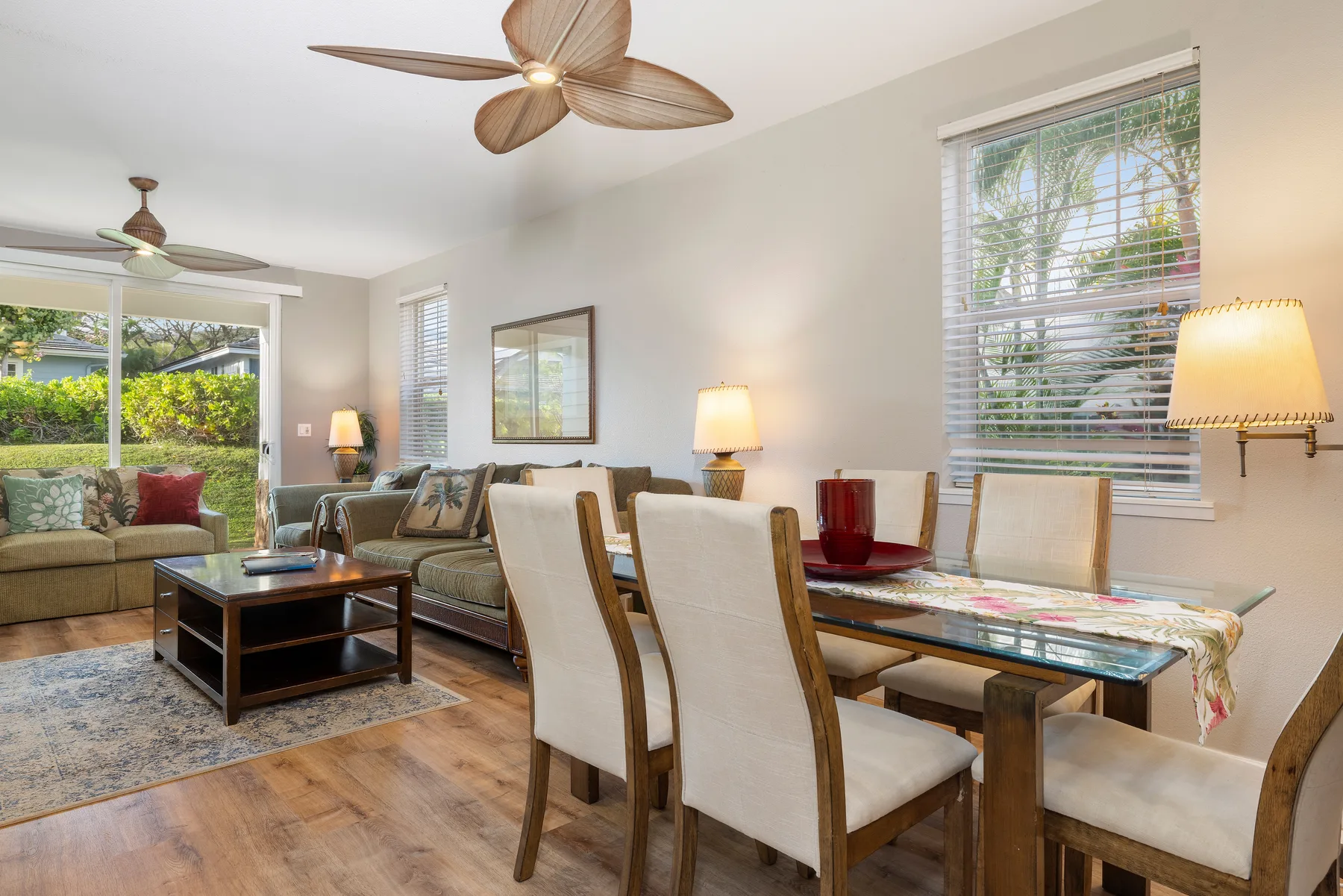 A living and dining area with seating, a dining table, and large windows.