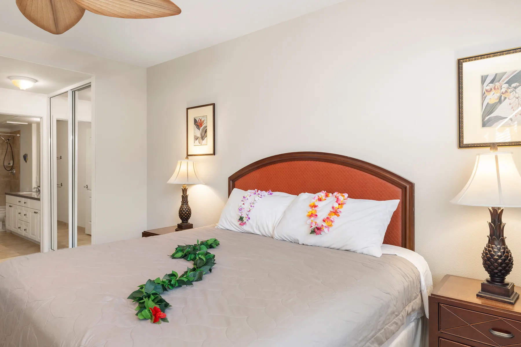 A bedroom with a large bed, decorative pillows, and bedside lamps.