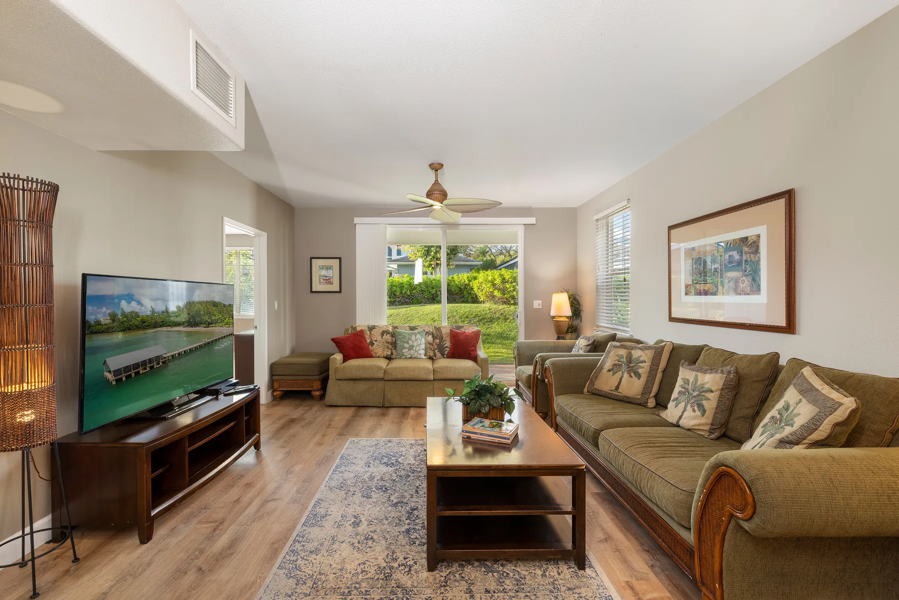 A living room with seating arranged around a coffee table and television.