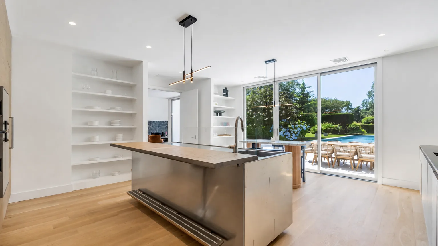 Una cocina luminosa con una gran isla central y ventanas con vistas a la vegetación.