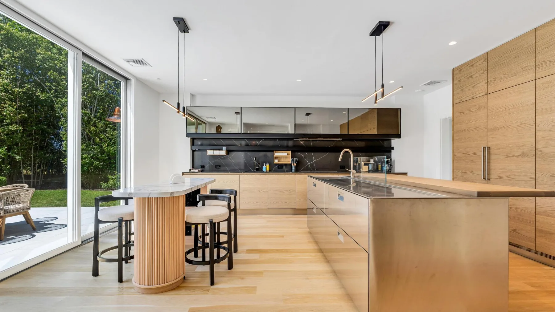 Una cocina moderna y luminosa con una gran isla y ventanas de piso a techo.