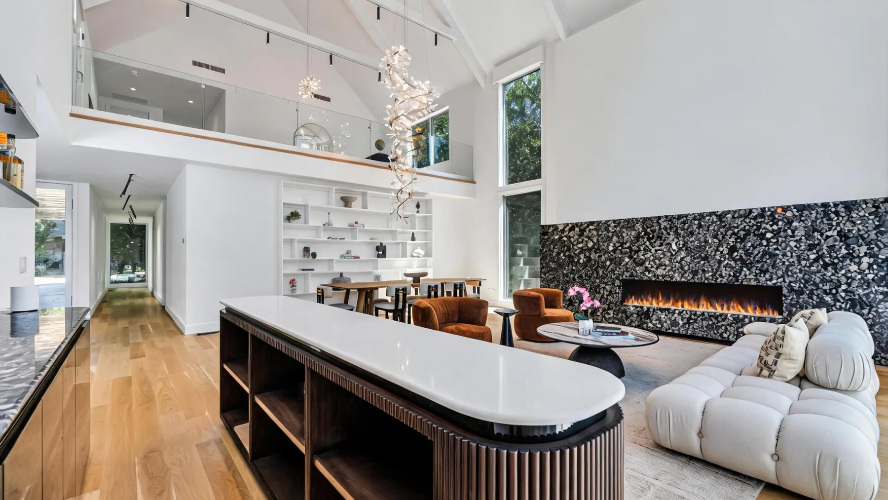 Una luminosa sala de estar y comedor de planta abierta, con una isla de cocina y ventanas altas.