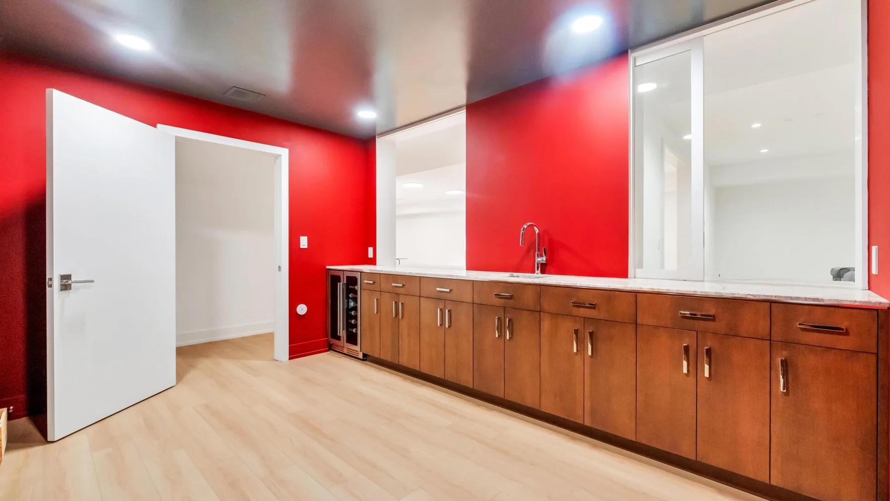 Una cocina luminosa con gabinetes de madera, una encimera y paredes rojas intensas.