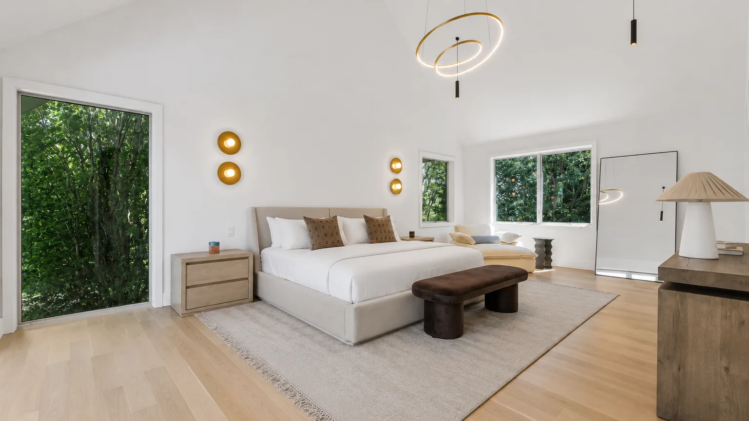 Un dormitorio luminoso con una cama grande, mesitas de noche y una alfombra.