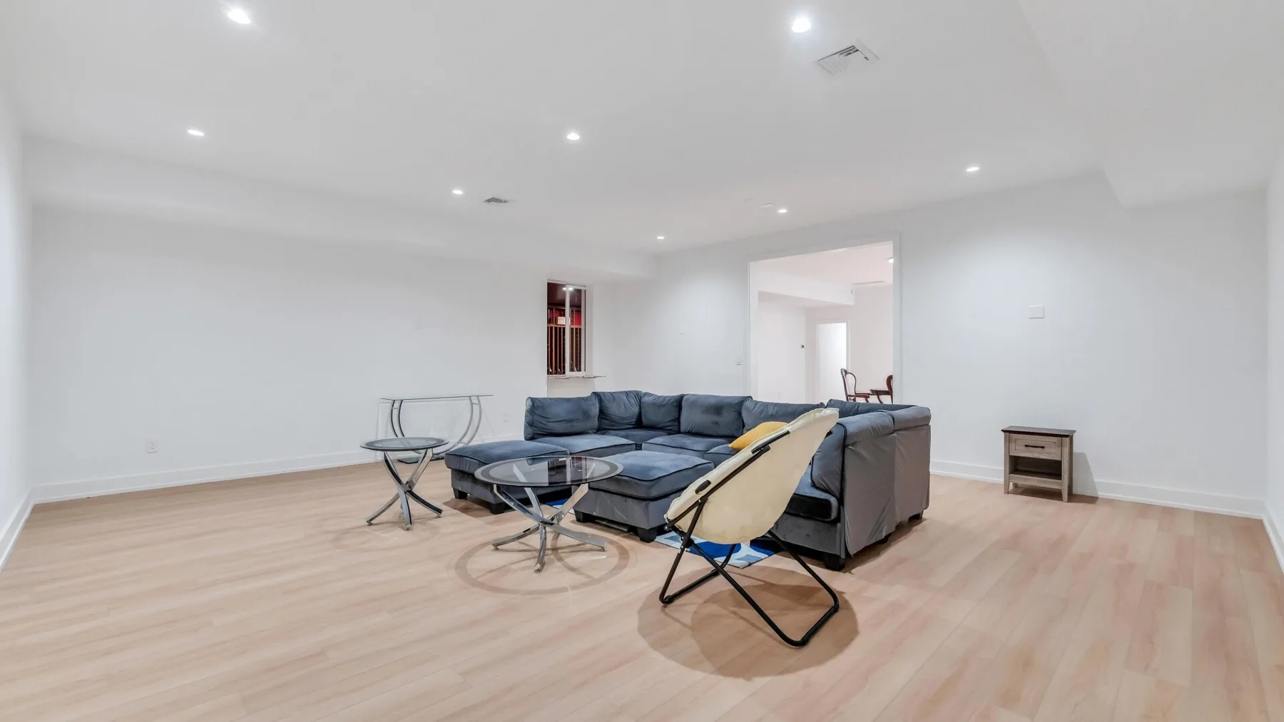 Una sala luminosa con asientos seccionales y una mesa de centro de vidrio.