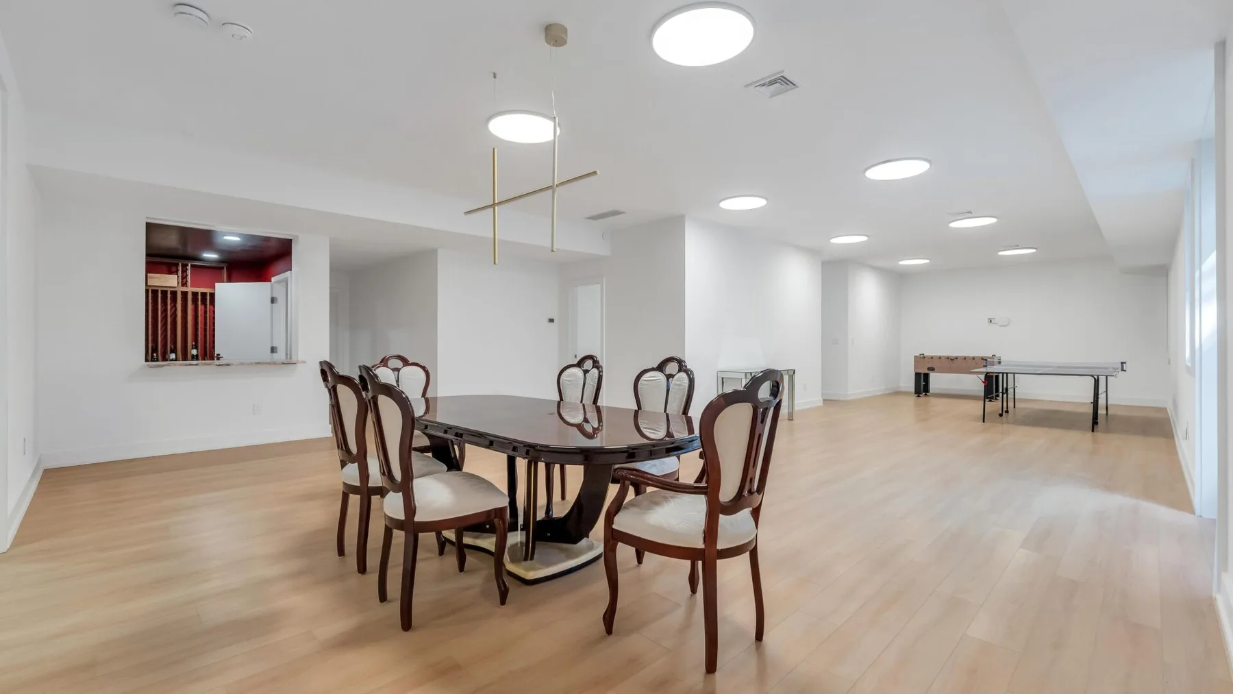 Comedor con una mesa oscura y sillas en una sala amplia y luminosa.
