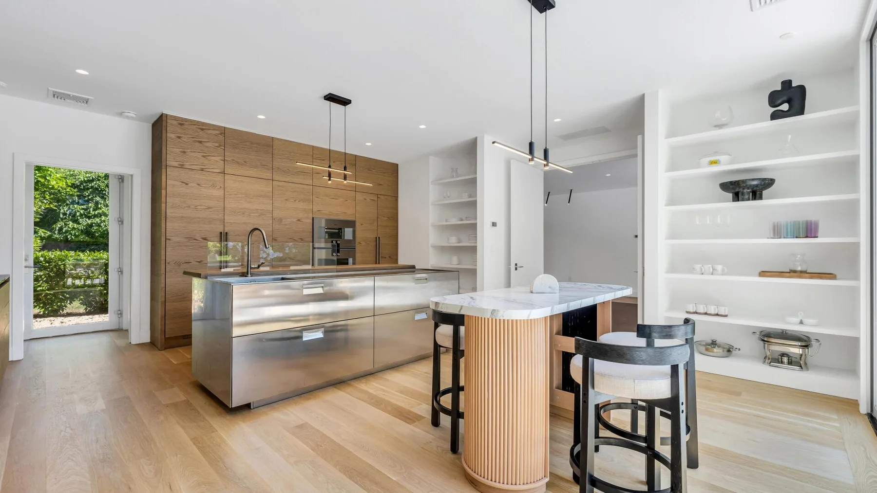 Una cocina moderna y luminosa con una isla central y una pequeña mesa de comedor.