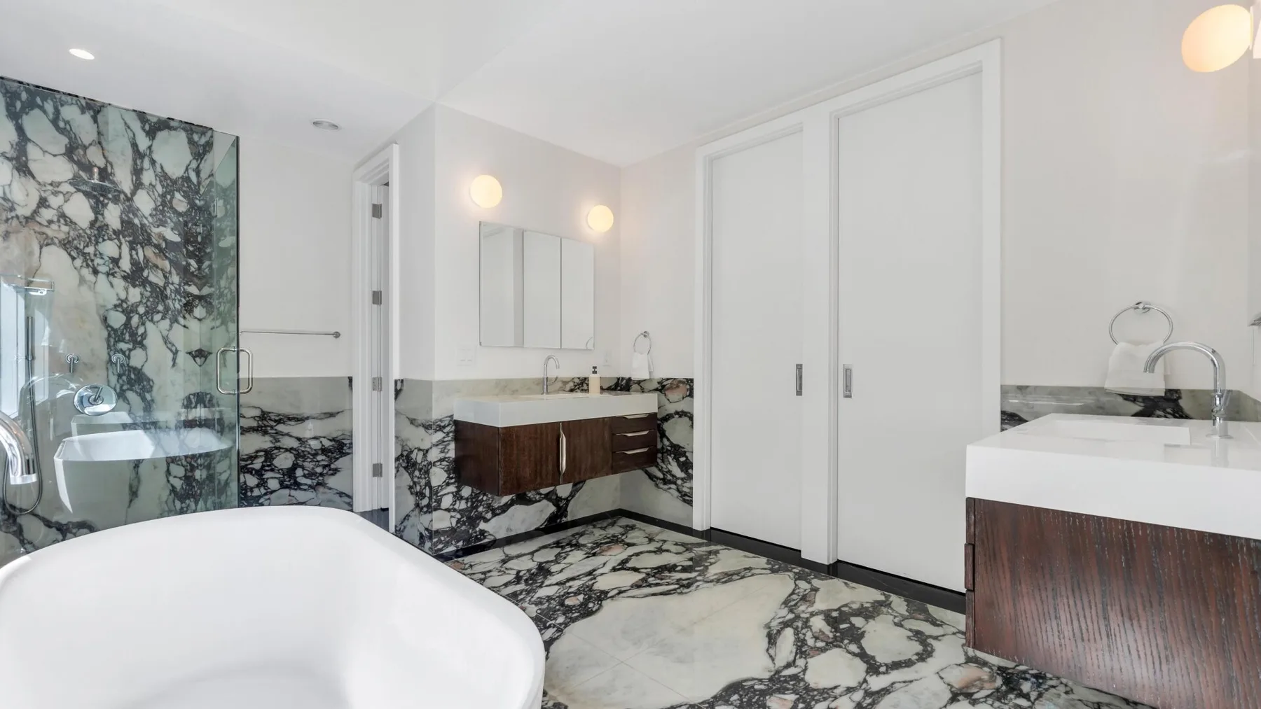 Un baño luminoso con bañera exenta, lavabo y zona de ducha.