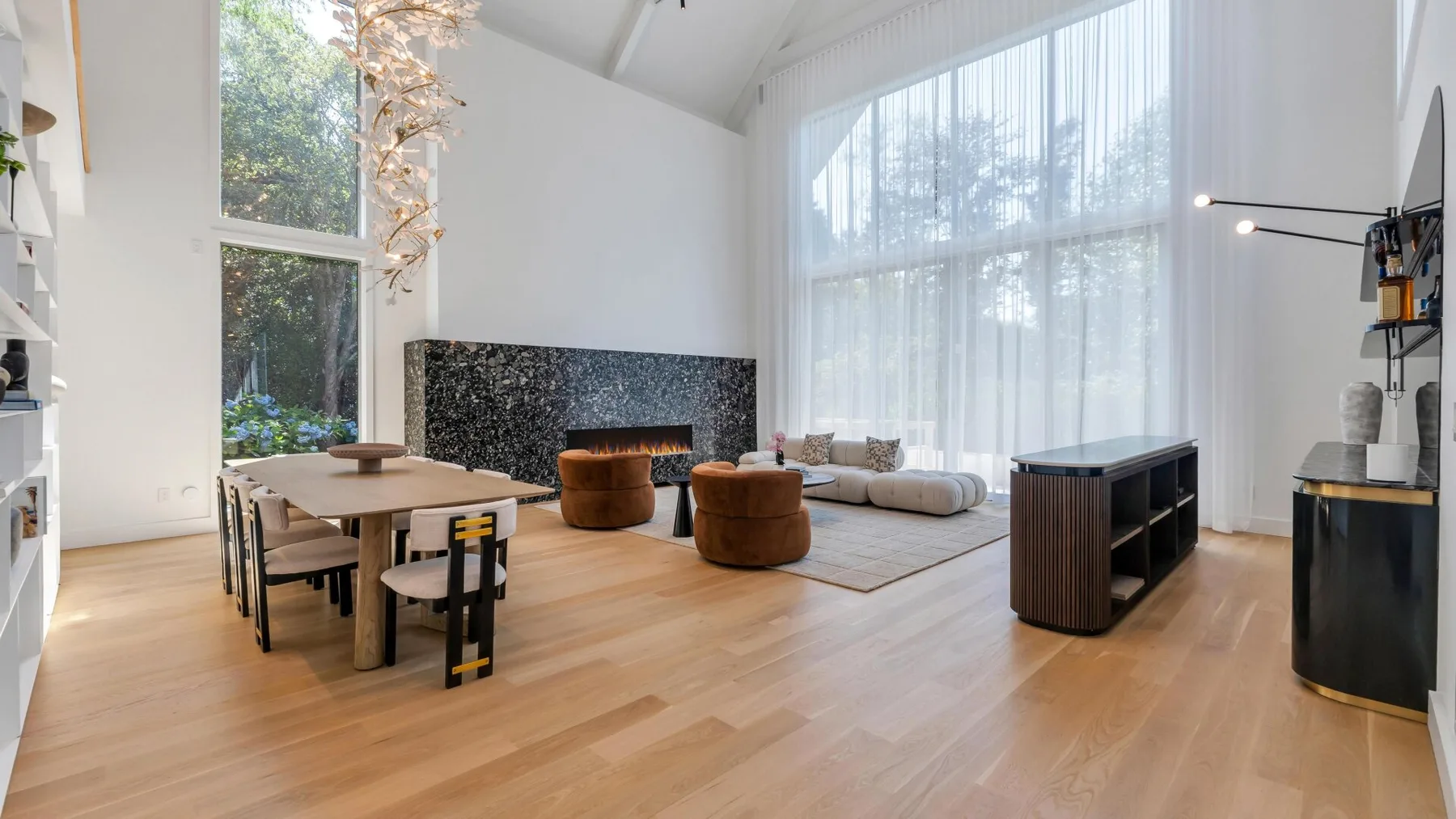 Un salón-comedor luminoso y diáfano con grandes ventanales y una mesa de comedor.