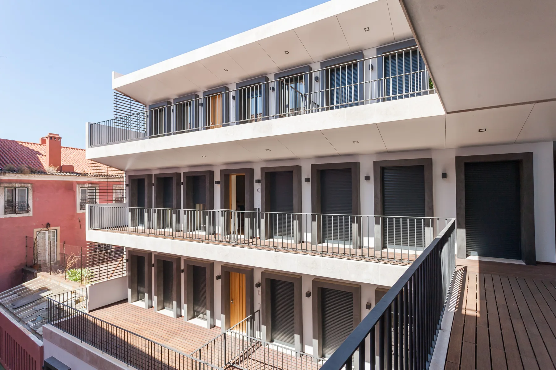 Edificio de apartamentos moderno con balcones que dan a un patio abierto.