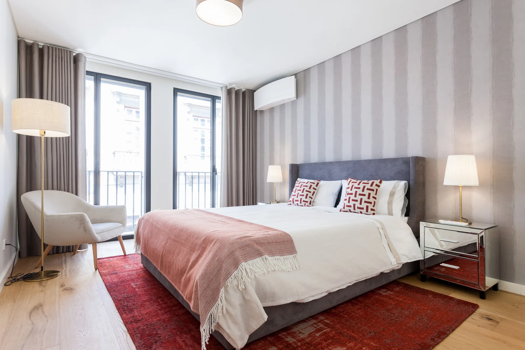 Dormitorio con una cama, mesitas de noche y una alfombra.