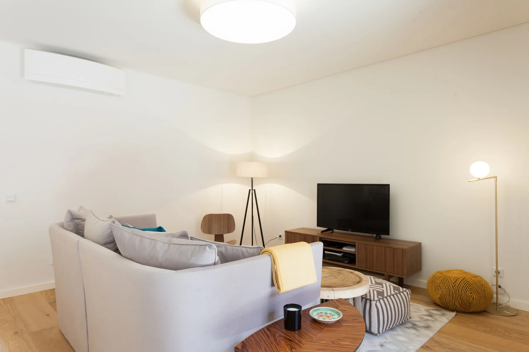 Una sala de estar con asientos, un televisor y una mesa de centro de madera.