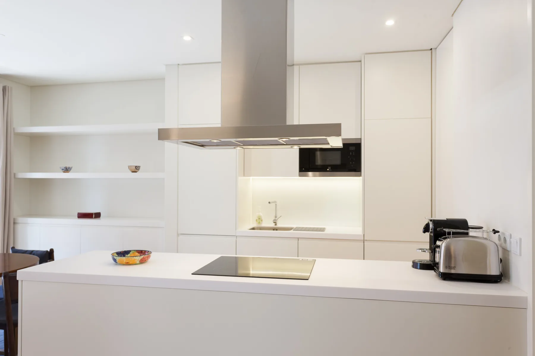 Una cocina moderna y luminosa con una isla central y una placa de cocción.