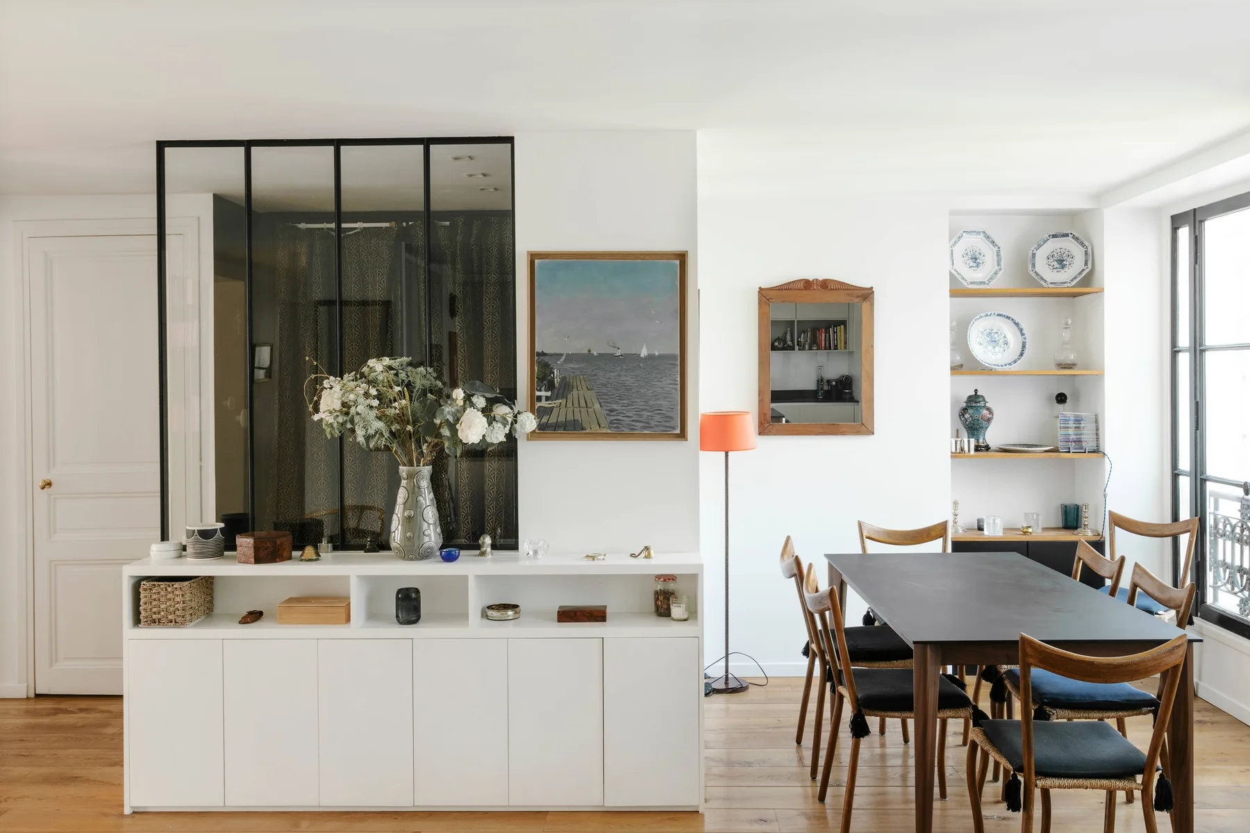 Comedor con una mesa larga y sillas junto a una ventana luminosa.