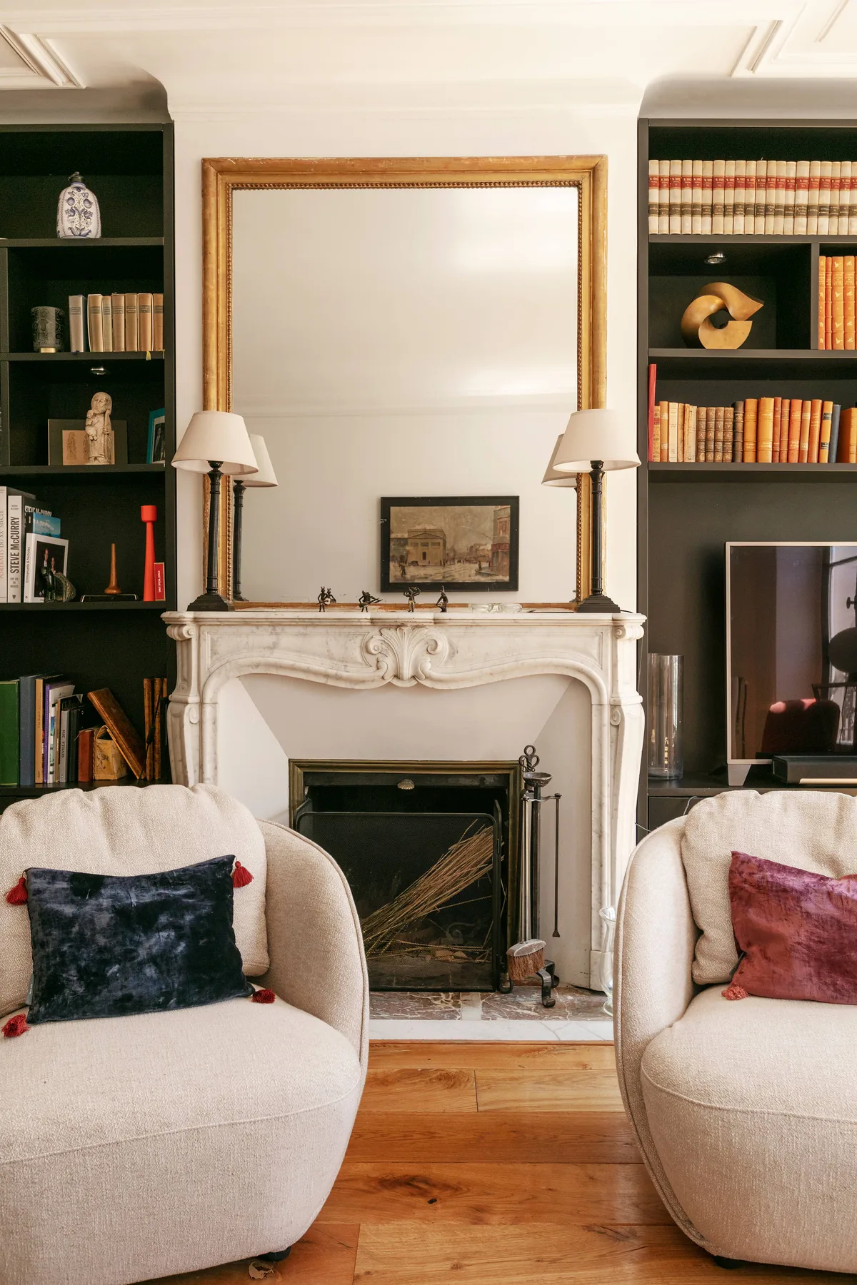 Una sala de estar con chimenea, estanterías y asientos tapizados.