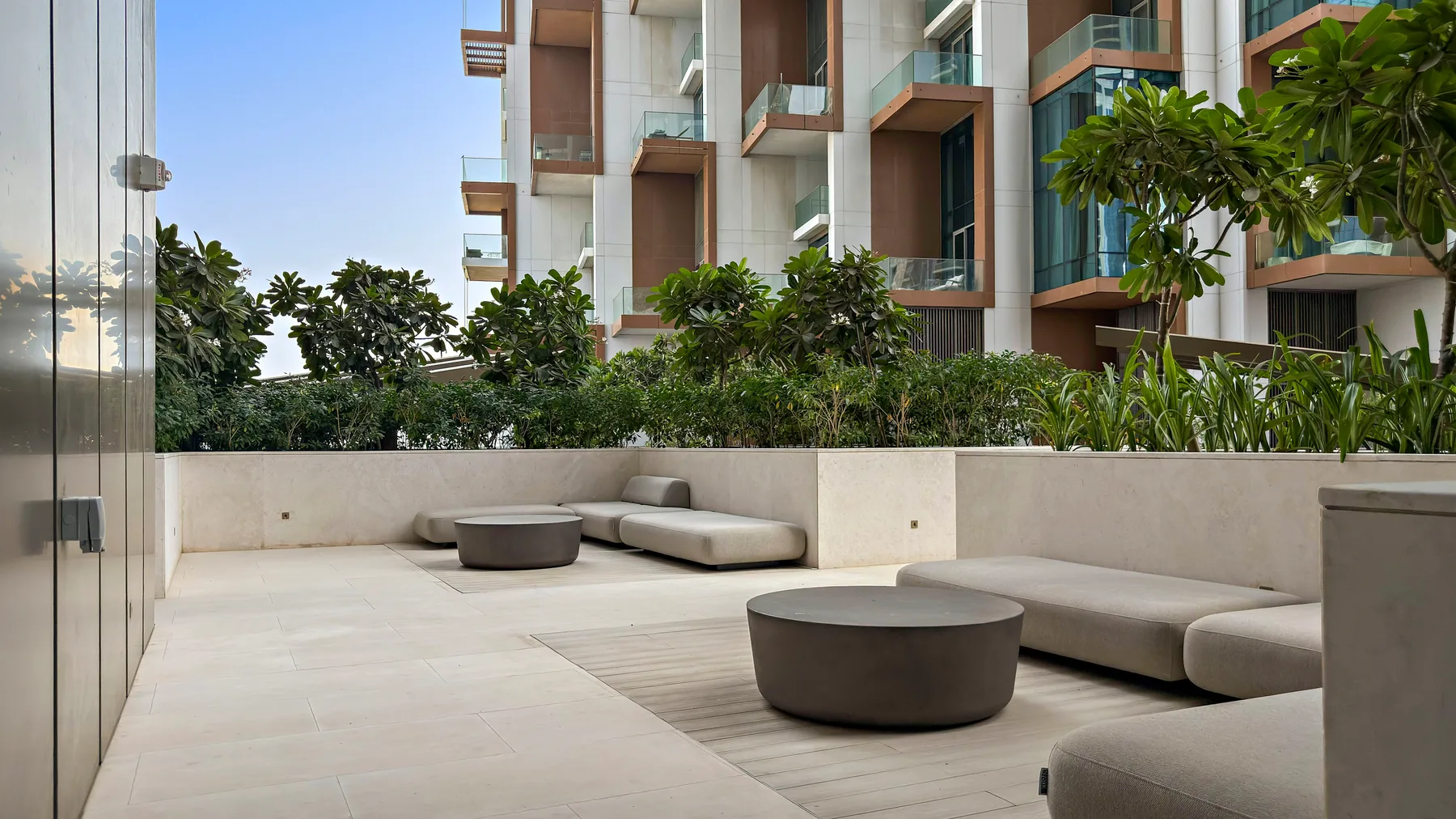 Una zona exterior de descanso con bancos bajos y jardineras.