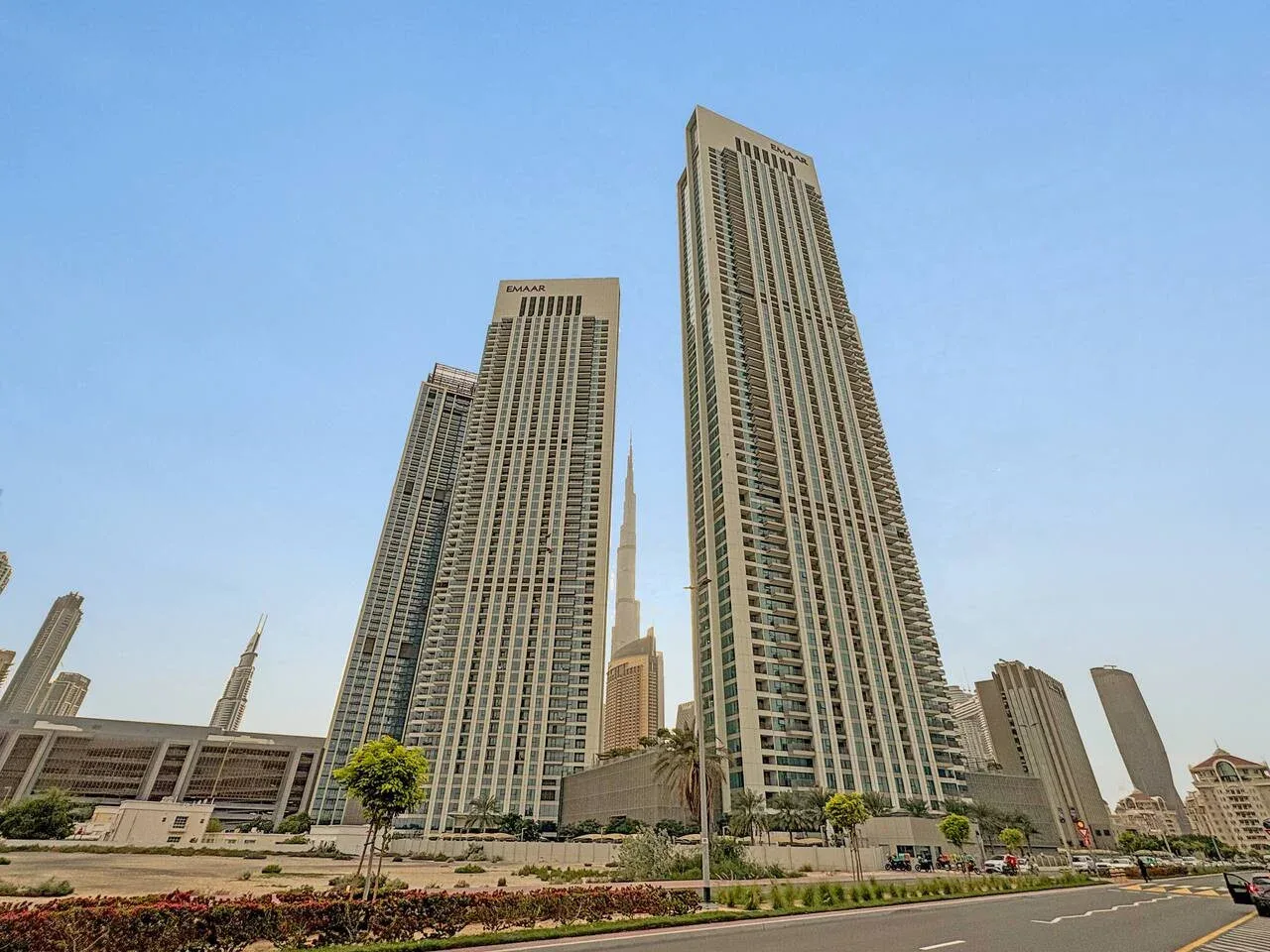 Un paisaje urbano con altas torres modernas junto a una carretera ajardinada.