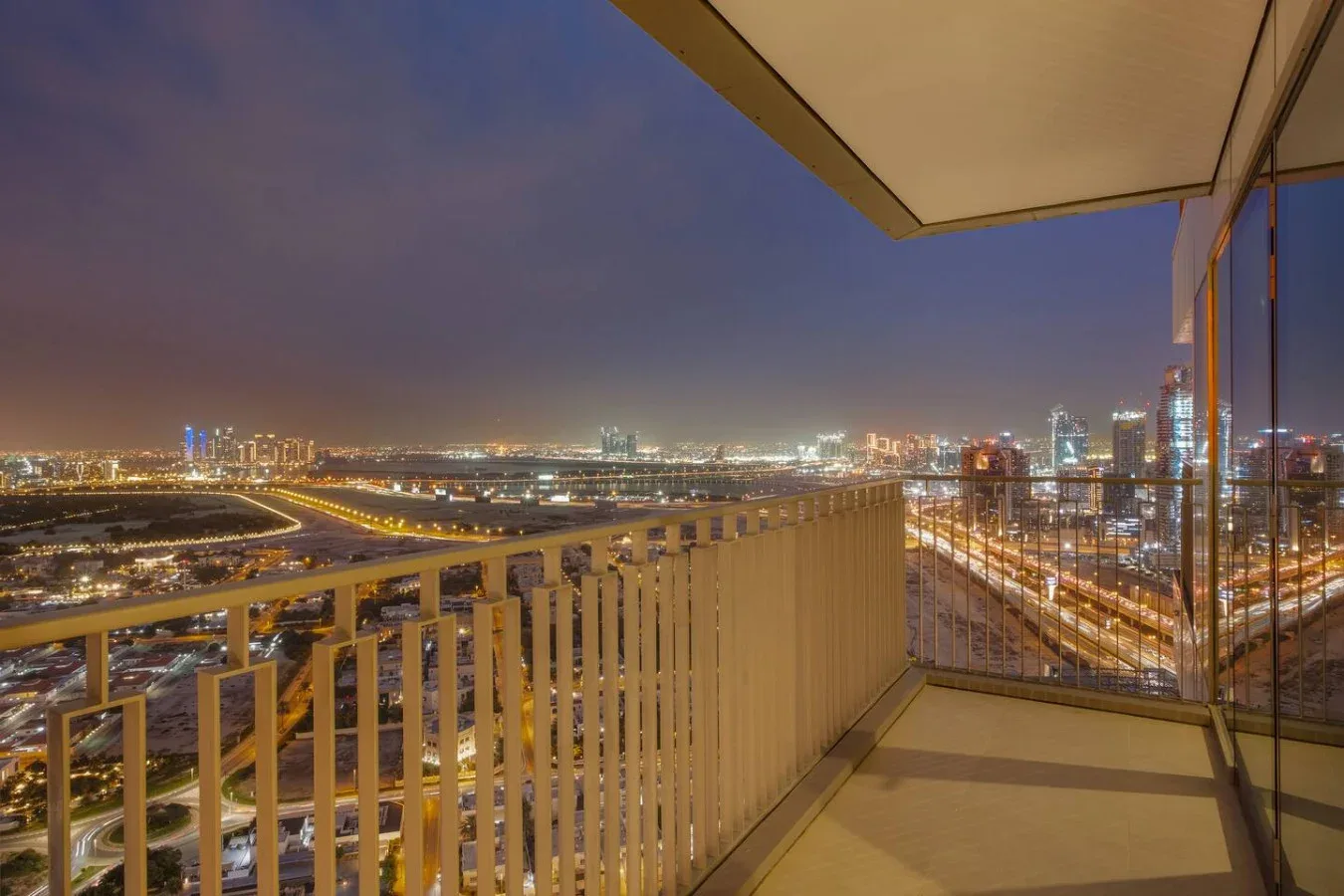 Un balcón ofrece vistas de un horizonte urbano iluminado por la noche.