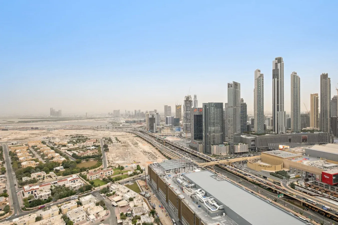 Un horizonte urbano de edificios altos junto a carreteras y barrios de edificios bajos.