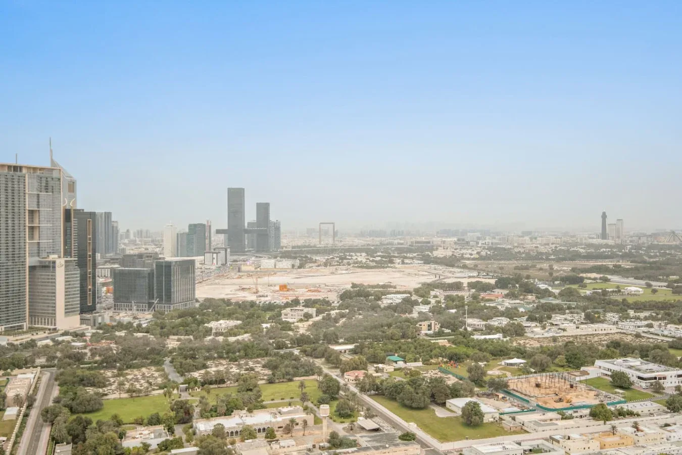 Una amplia vista urbana muestra edificios modernos entre construcciones bajas y zonas verdes.