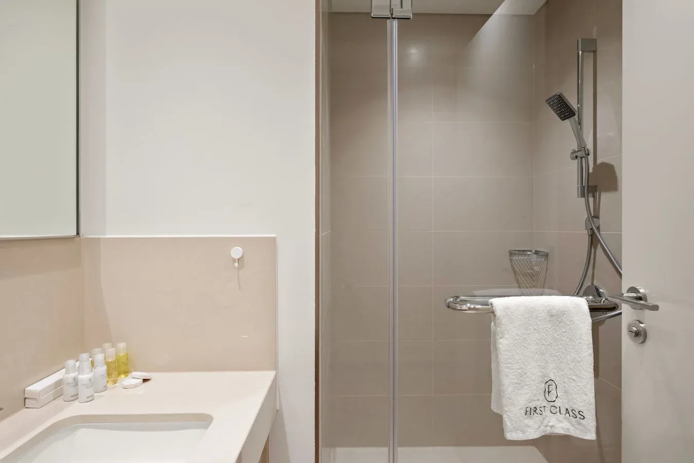 Un baño con lavabo y una zona de ducha con mampara de vidrio.