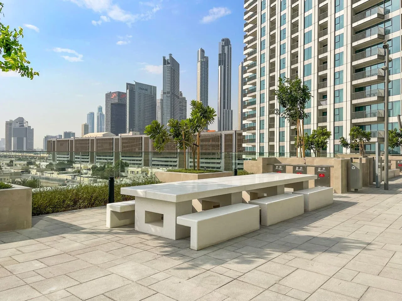 Una terraza al aire libre con asientos integrados tiene vistas a varios edificios altos.