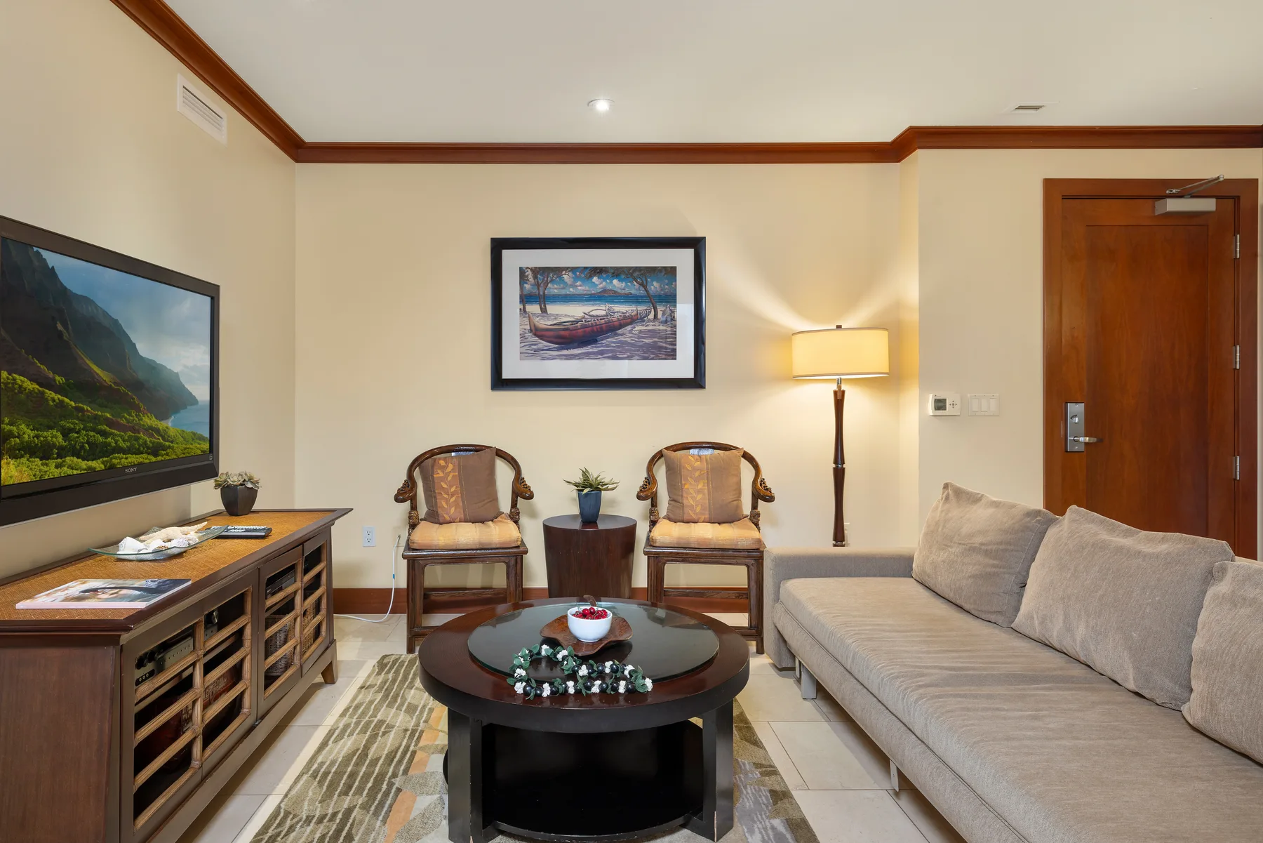 Sala de estar con asientos, una mesa de centro y un televisor.