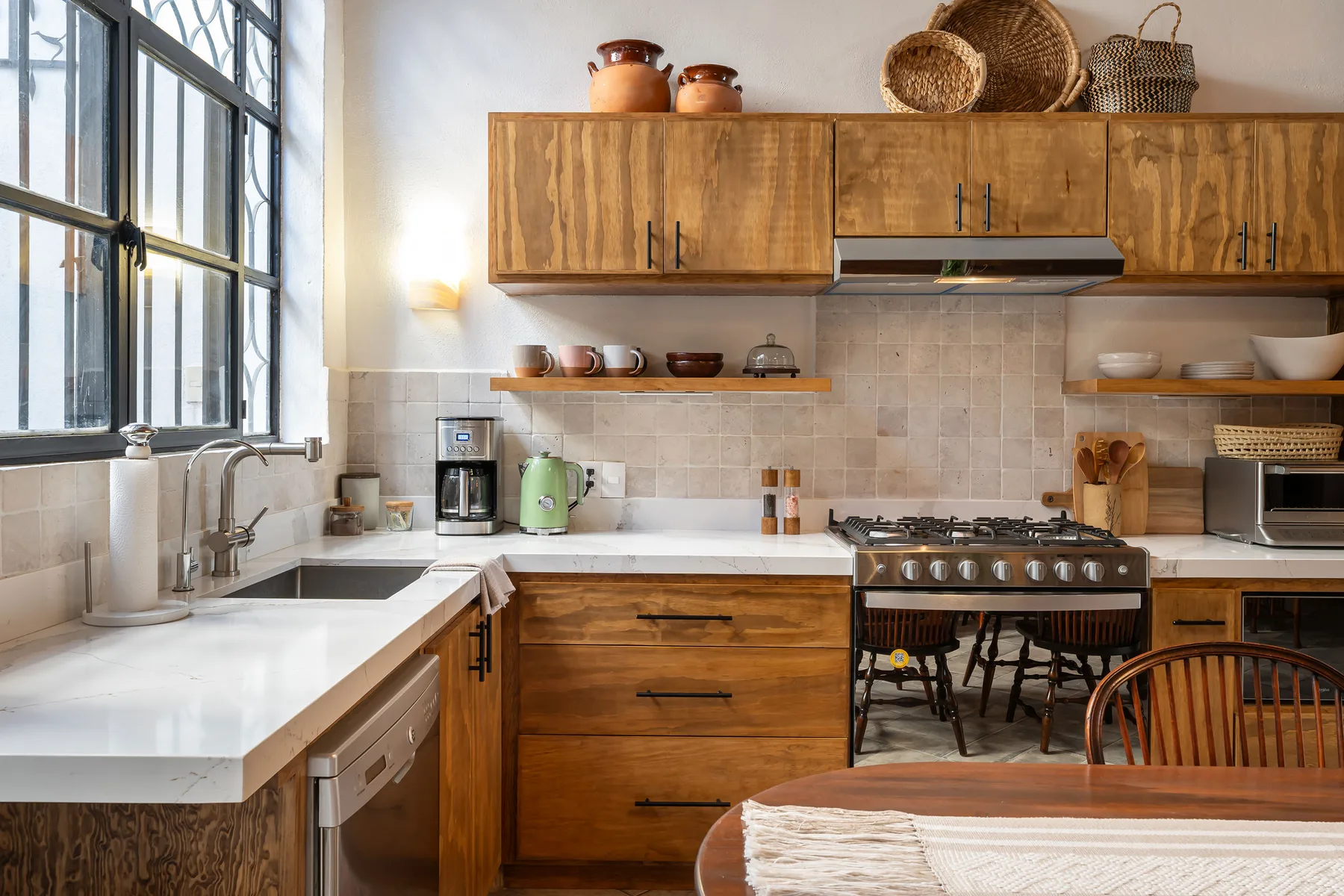 A kitchen with wooden cabinets, a cooking range, and a long countertop.