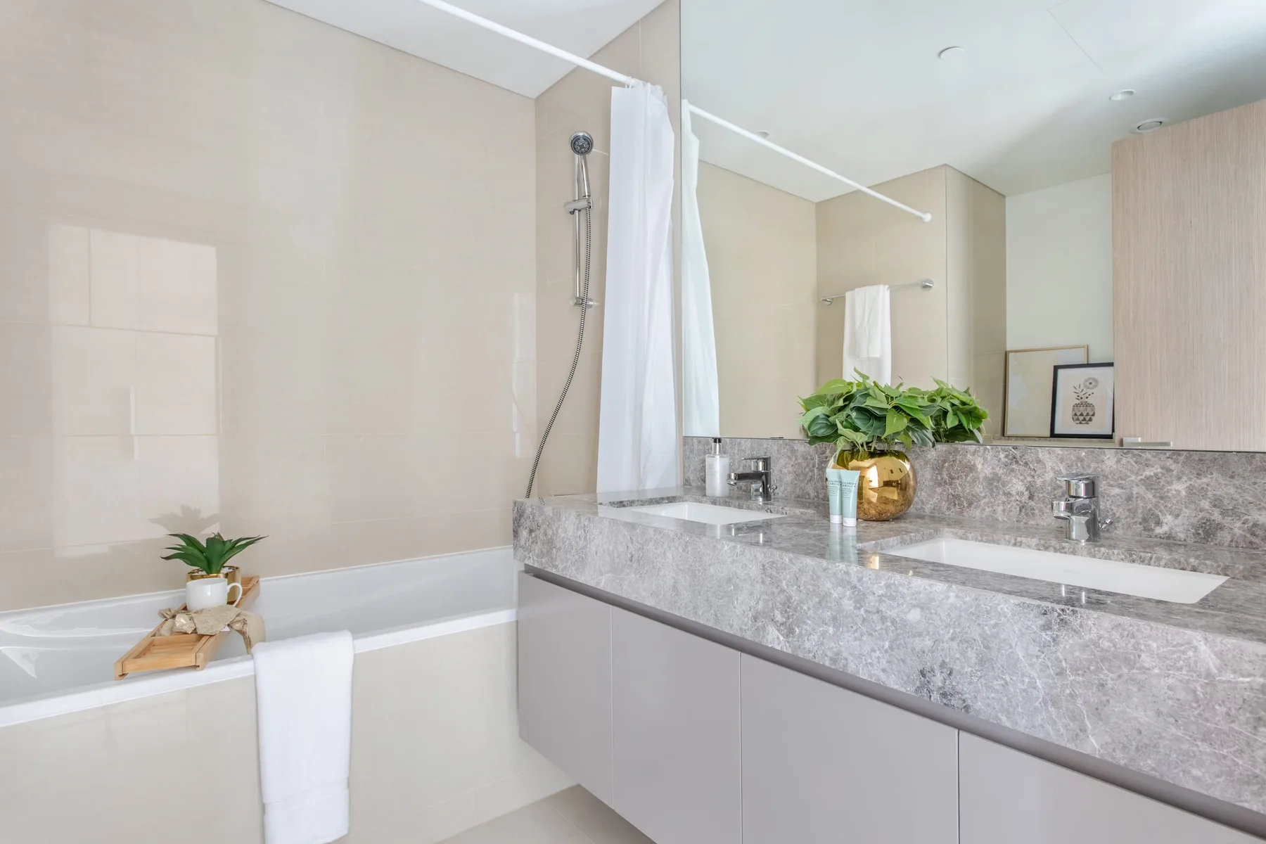 Un baño luminoso con bañera, ducha y un tocador largo.