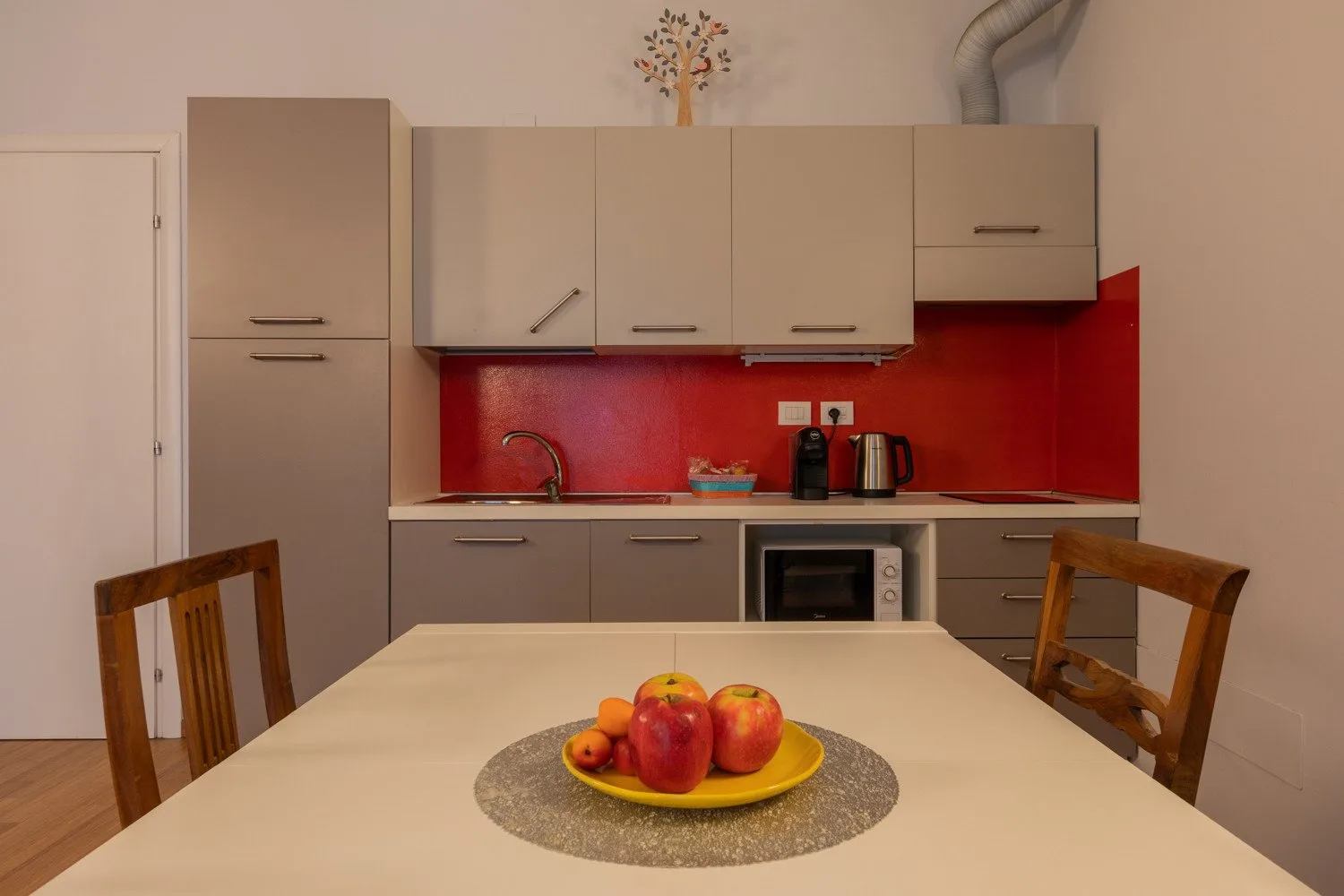 Una zona de comedor en la cocina con una mesa y un plato de fruta.
