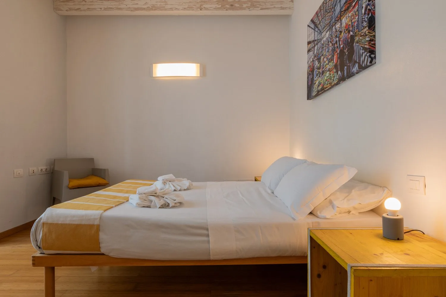 Un dormitorio con una cama bien arreglada y una pequeña mesita de noche.