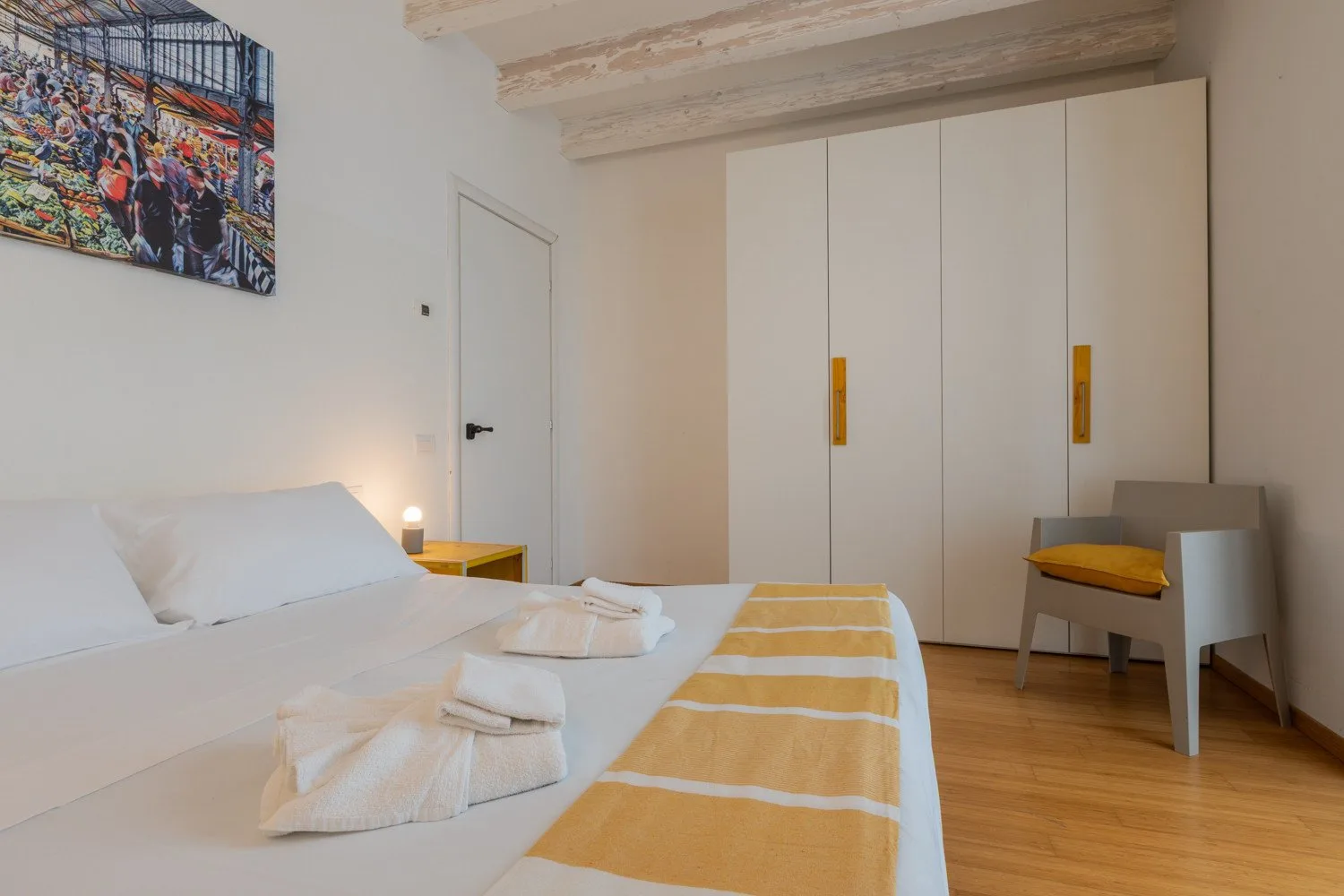 Un dormitorio con una cama, un armario y una silla.