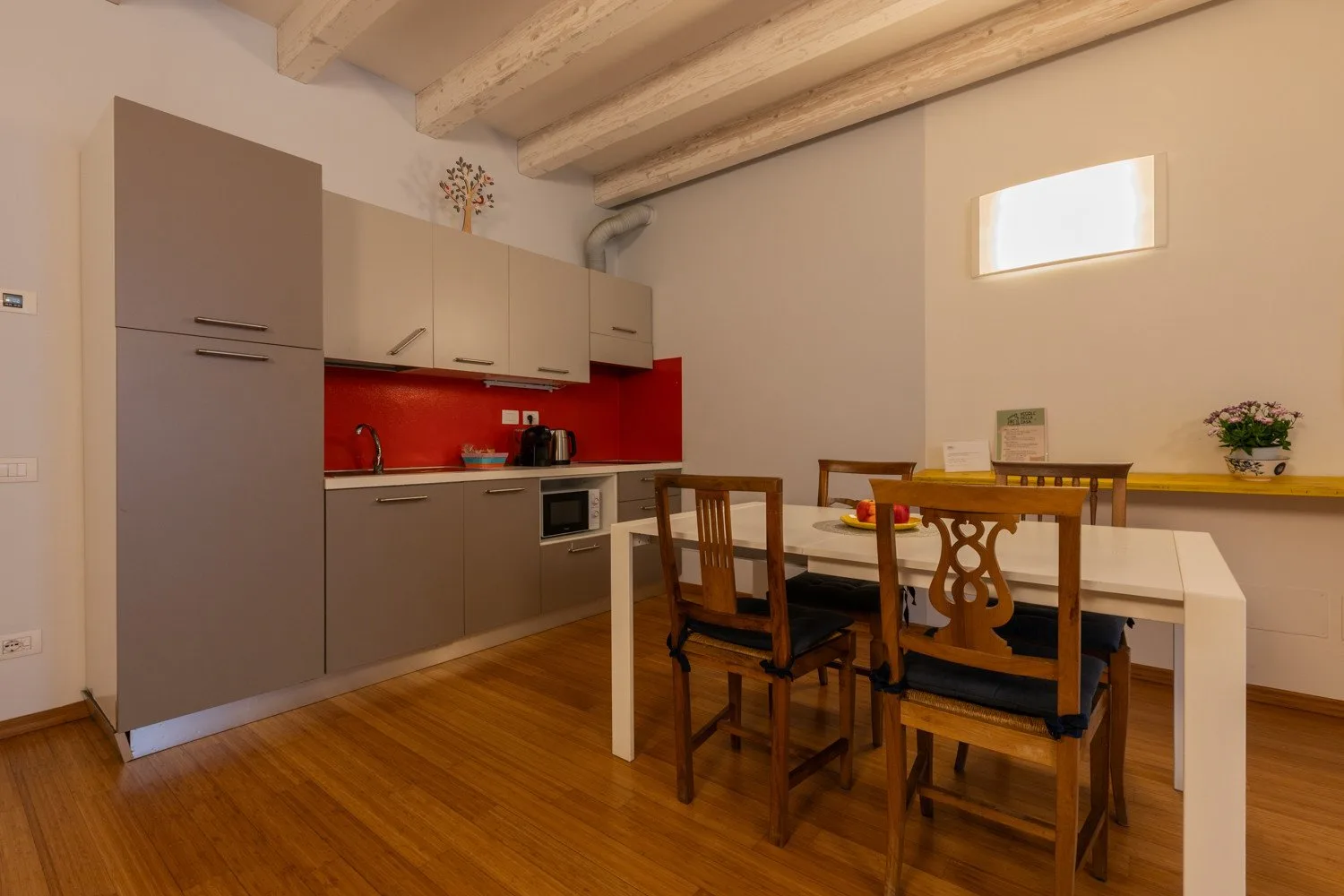 Una cocina y comedor con mesa, sillas y armarios.